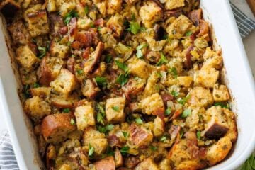 Turkey stuffing recipe in a white casserole dish with parsley garnish chopped sourdough bread