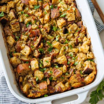 Turkey stuffing recipe in a white casserole dish with parsley garnish chopped sourdough bread