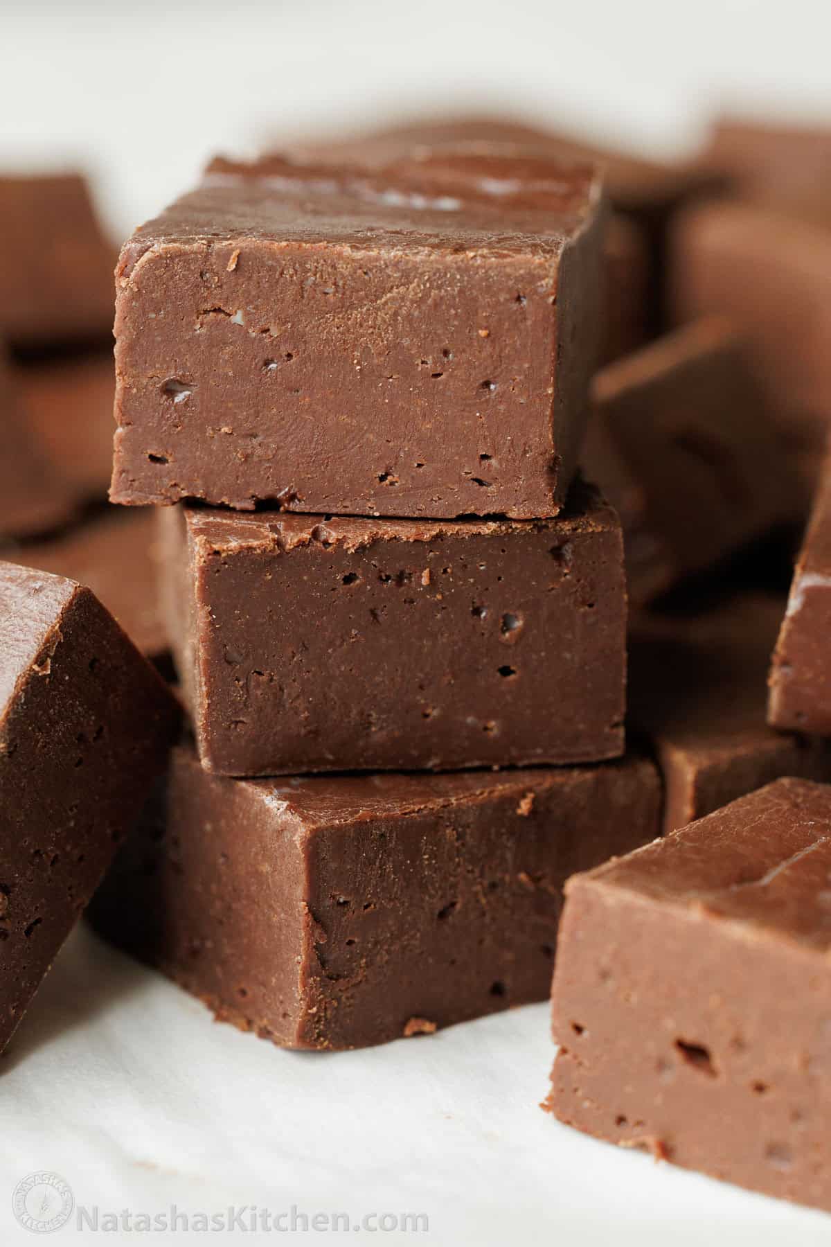 Three squares of chocolate fudge stacked
