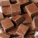 Squares of easy chocolate fudge recipe on a white plate