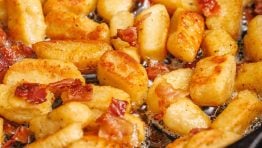browned ricotta gnocchi recipe in a saute pan with bacon
