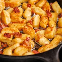 browned ricotta gnocchi recipe in a saute pan with bacon