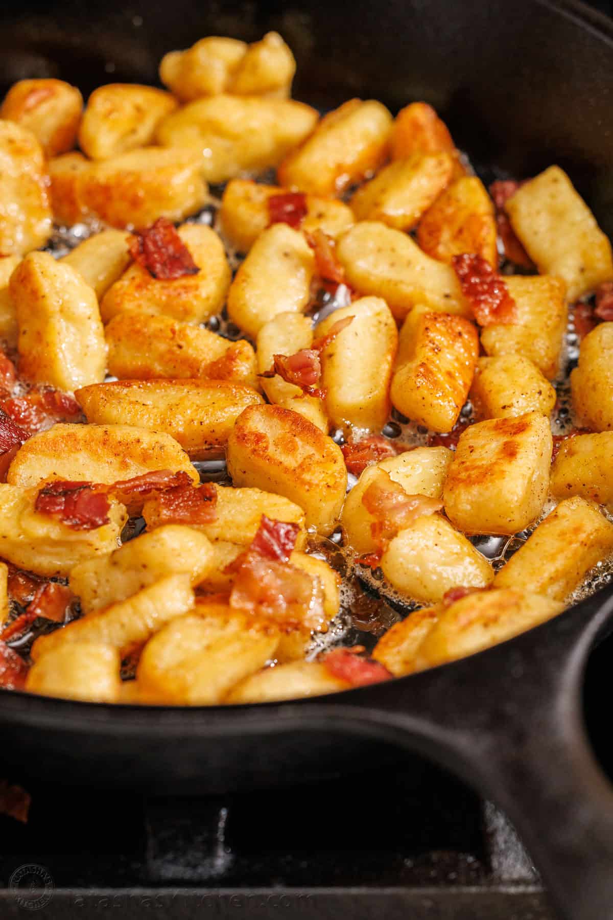 Ricotta Gnocchi satisfy the craving for gnocchi with very little effort. No need to fuss with potatoes since the star ingredient is ricotta cheese. browned ricotta gnocchi recipe in a saute pan with bacon