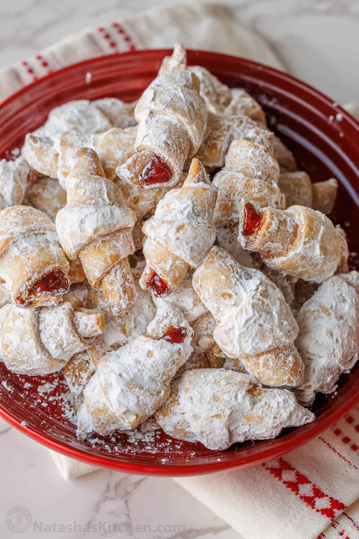 Tray of rugelach cookies in a festive red bowl with tea towel