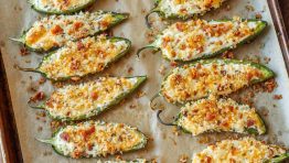 tray of spicy appetizers with crispy bacon topping and stuffed peppers