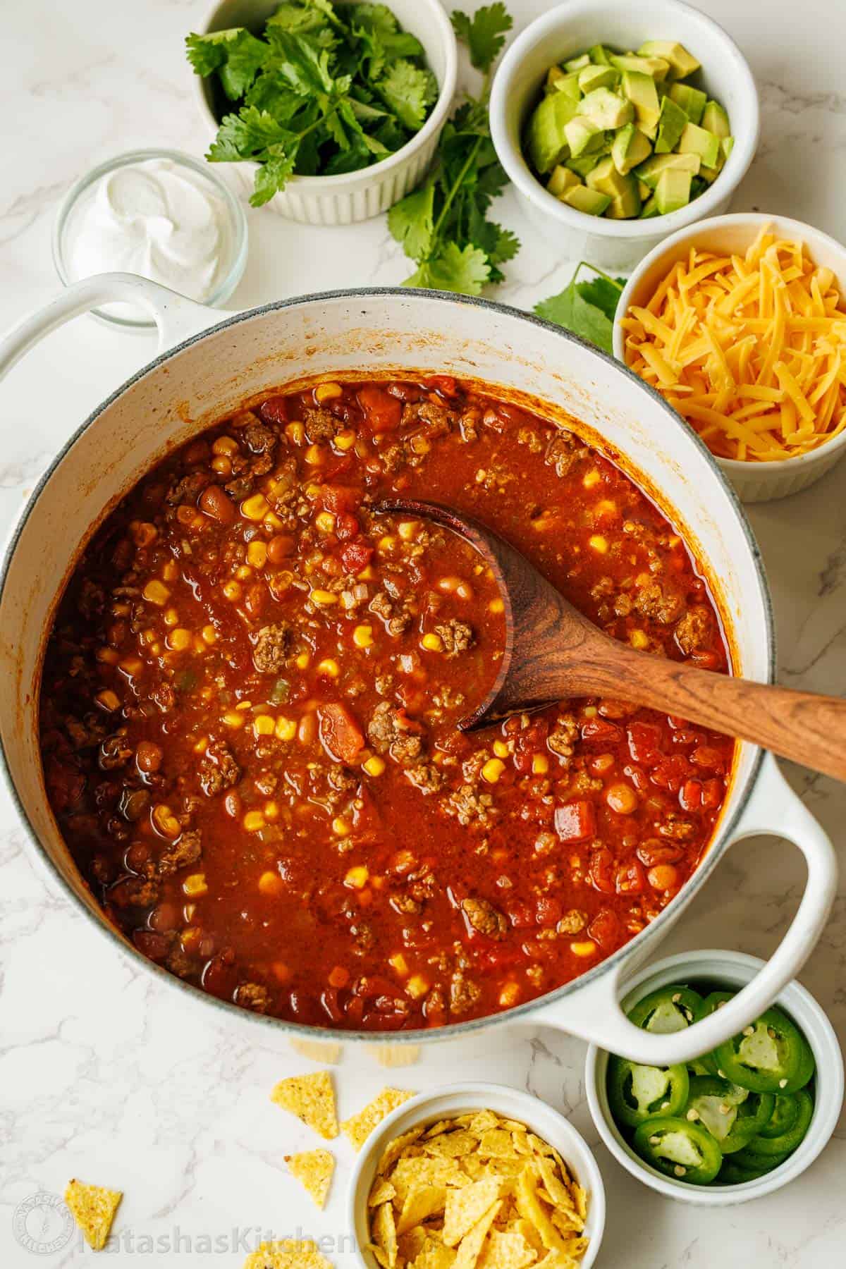Easy taco soup combines Tex-Mex flavors of tacos into a hearty soup. You'll love this 1-pot, 30-minute meal with all the best taco toppings! Large pot of stew with toppings in small bowls