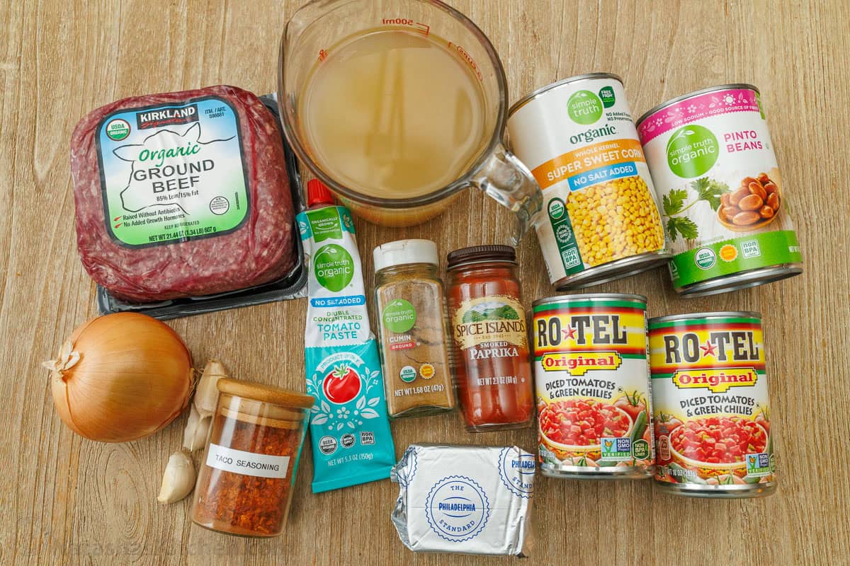 Easy taco soup combines Tex-Mex flavors of tacos into a hearty soup. You'll love this 1-pot, 30-minute meal with all the best taco toppings! ingredients for delicious Tex-Mex stew including ground beef, onion, garlic, seasoning, tomato paste, chicken stock, cumin, paprika, cream cheese, rotel, sweet corn and pinto beans