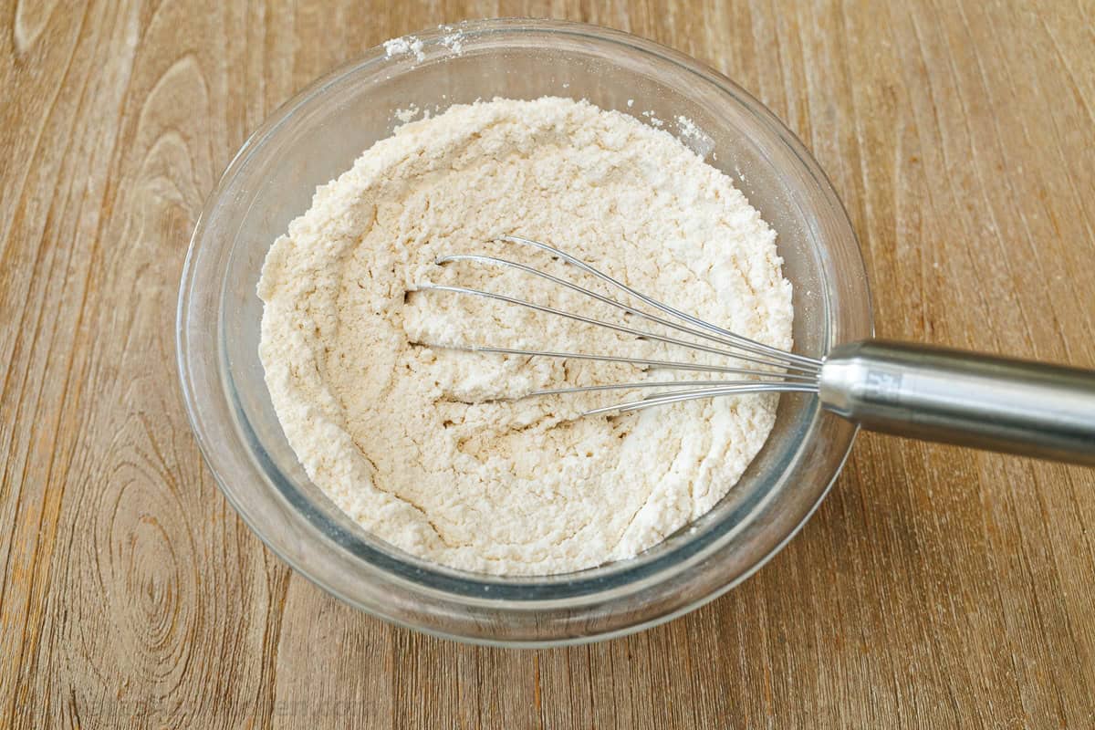 dry ingredients mixed in a clear bowl with a whisk