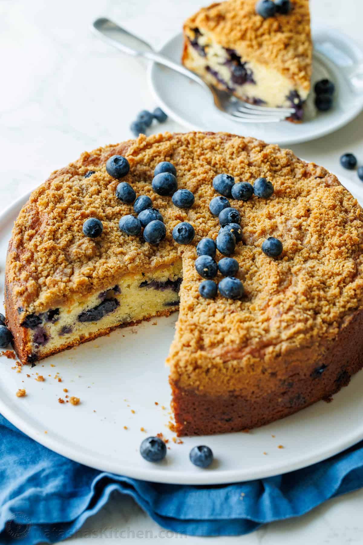 slice missing and plated from a round blueberry coffee cake