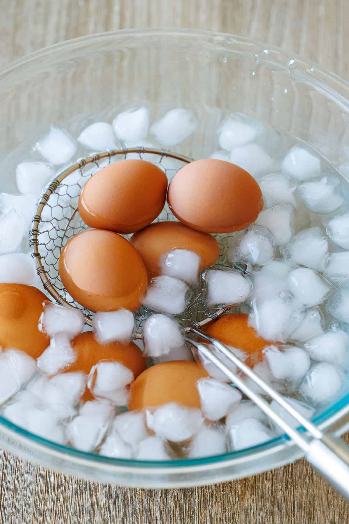 how to peel a hard boiled egg using ice cubes and a strainer