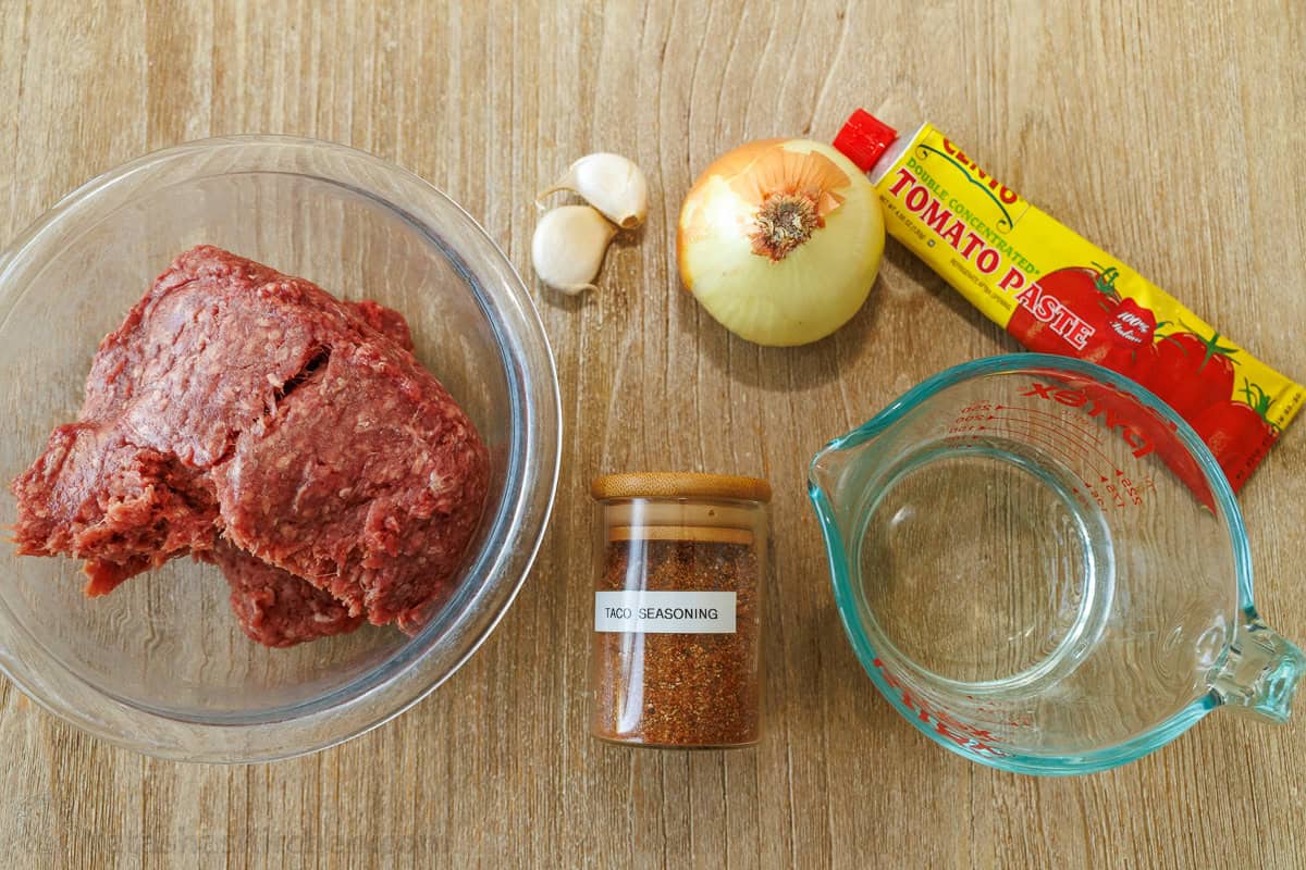 easy mexican dinner recipe with ground meat, garlic, onion, tomato paste, taco seasoning and water