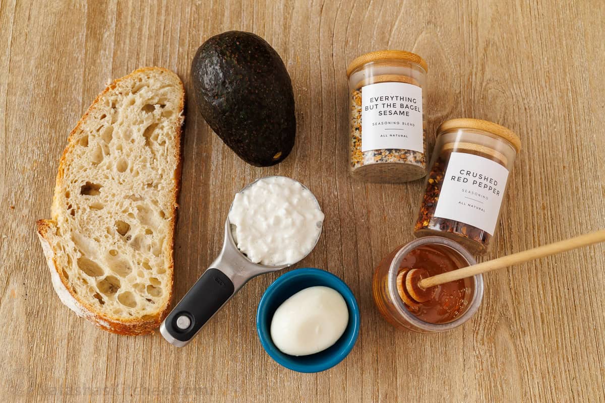 Best high-protein avocado toast recipe with egg, cottage cheese, bagel seasoning and honey in 10 minutes. It's our go-to breakfast recipe! Ingredients for the best high-protein breakfast including bread, healthy fat, dairy, egg, everything but the bagel seasoning, crushed red pepper and honey