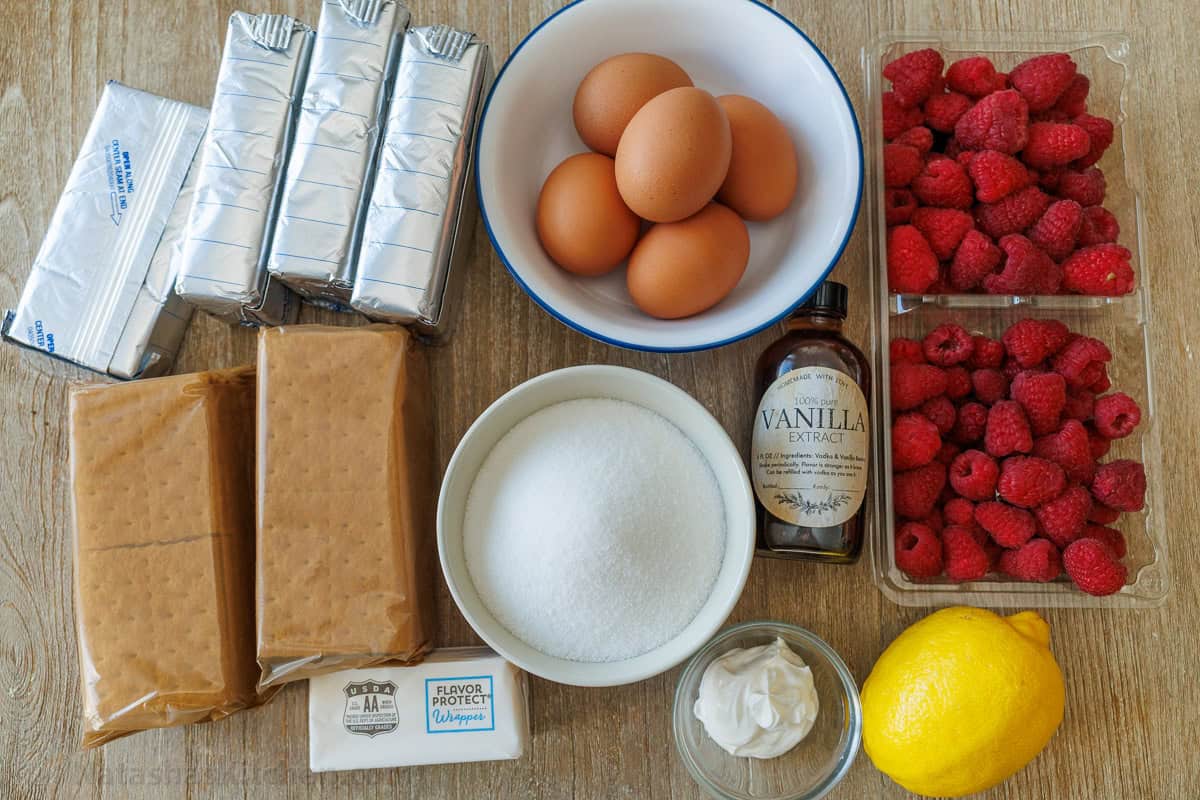 Ingredients for the best Easter dessert including berries, lemons, sugar, cream cheese, eggs, graham crackers, vanilla extract, sour cream, and butter.