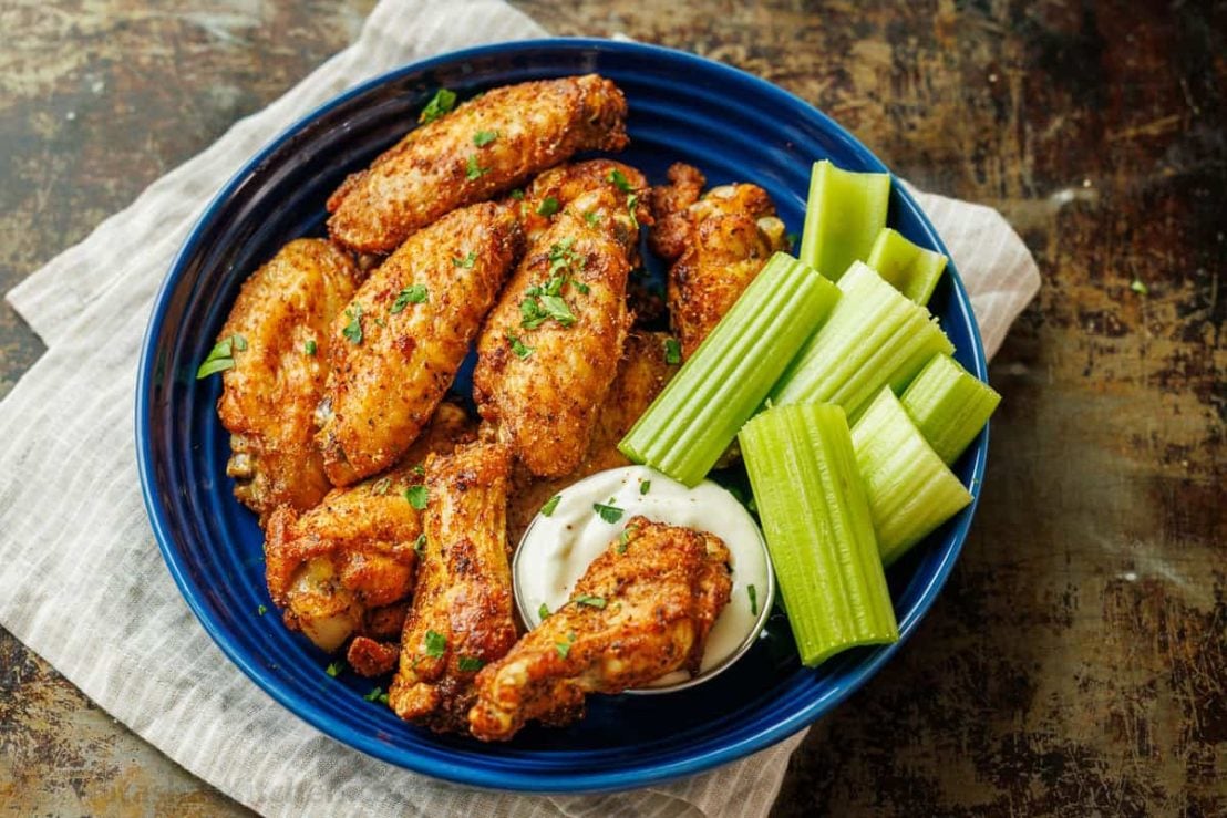 Extra Crispy Air Fryer Chicken Wings served on a blue plate with celery and dipping sauce