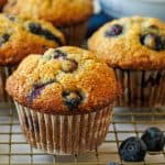 blueberry Banana Muffins on a cooling rack with white cupcake liners