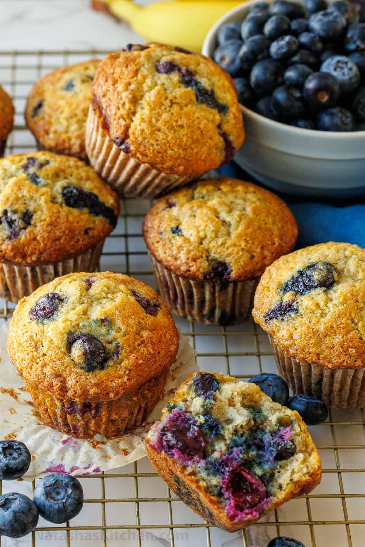 Easy Blueberry Banana Muffins bake up moist, tall, domed, and fluffy with great banana flavor and plenty of juicy blueberries. Blueberry banana muffins loaded with blueberries inside sitting with a bowl of blueberries