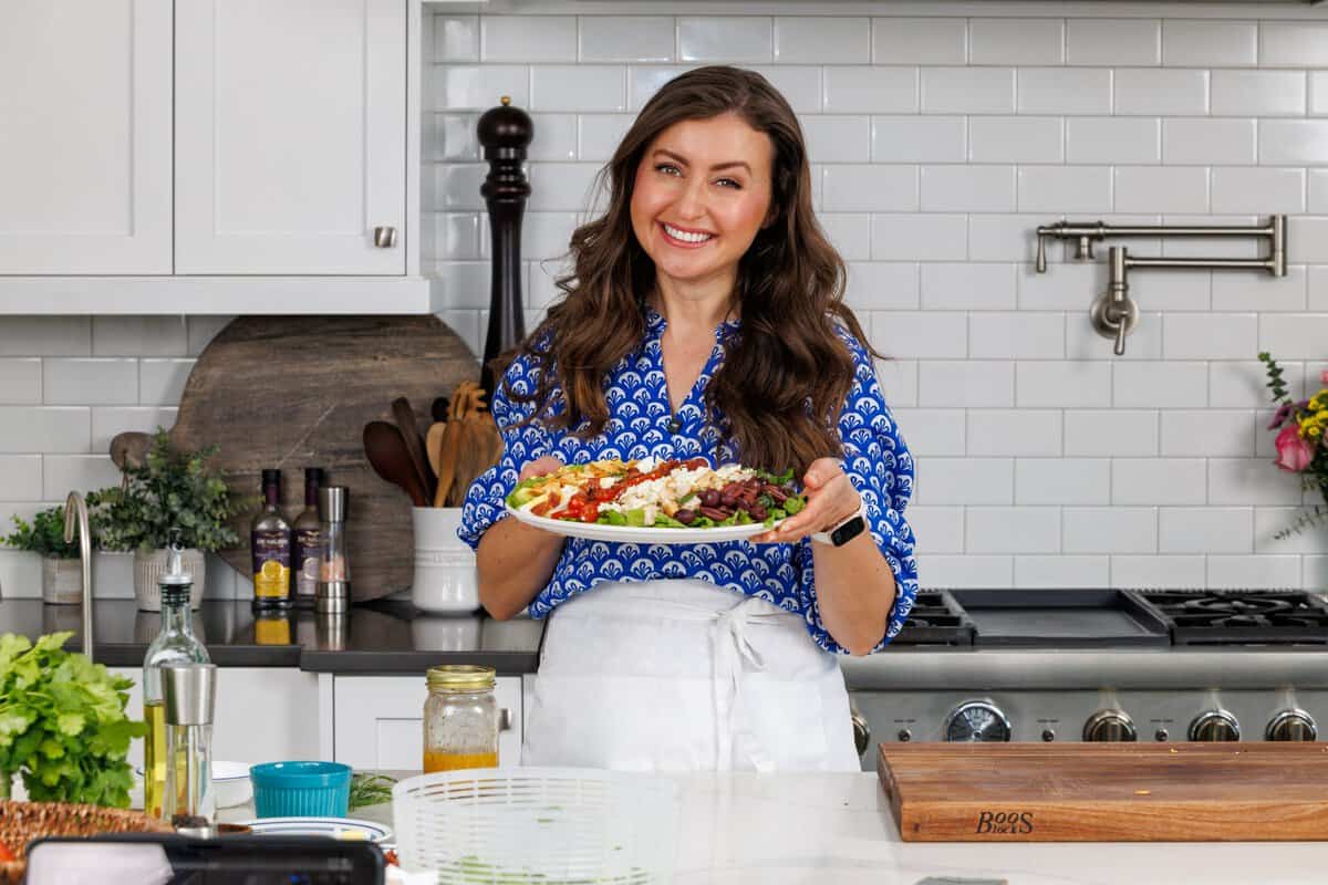 Natasha holding a platter of Greek Salad
