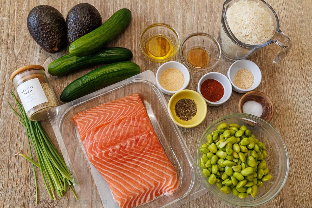 Ingredients for high-protein dinner including jasmine rice, garlic powder, paprika, salt, pepper, onion powder, olive oil, honey, edamame, fresh fish fillet, cucumber, avocado, sesame seeds, and green onions