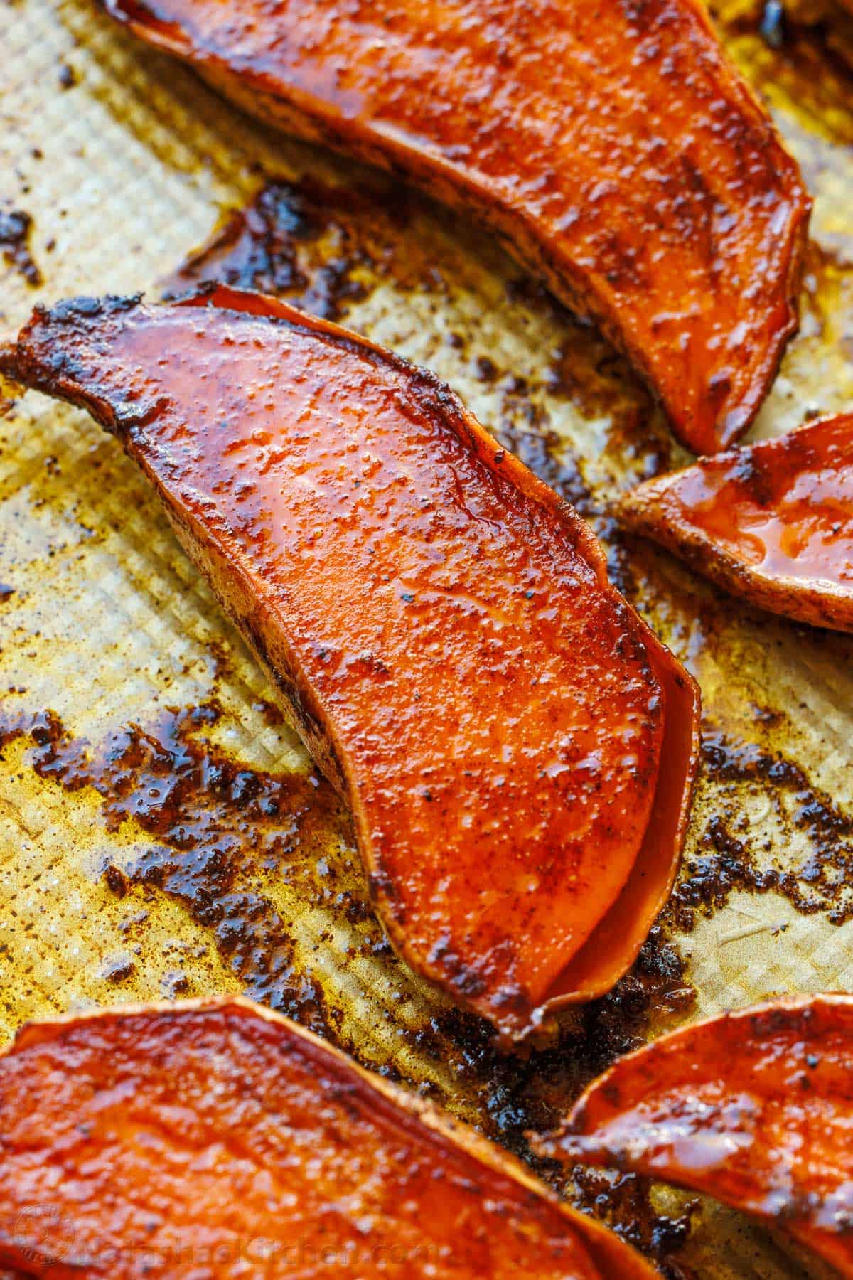 caramelized roasted sweet potato halves on a sheet pan