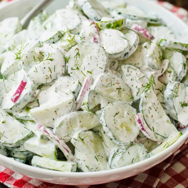 Creamy cucumber salad with red onion and dill in a sour cream dressing