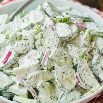 Creamy cucumber salad recipe garnished with dill