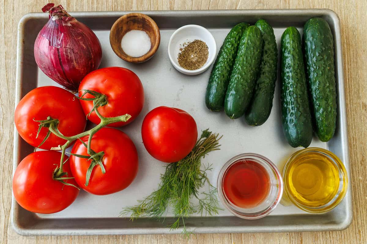 ingredients for fresh summer side dish recipe with vegetables from the garden and simple dressing with dill, oil, and vinegar