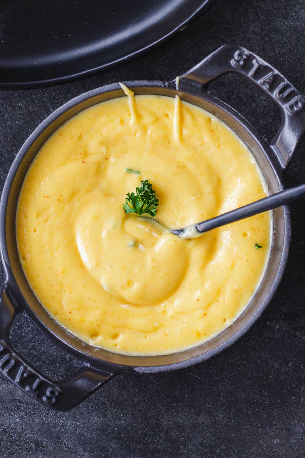 Hollandaise Sauce Recipe in a cast iron crock pot with serving spoon