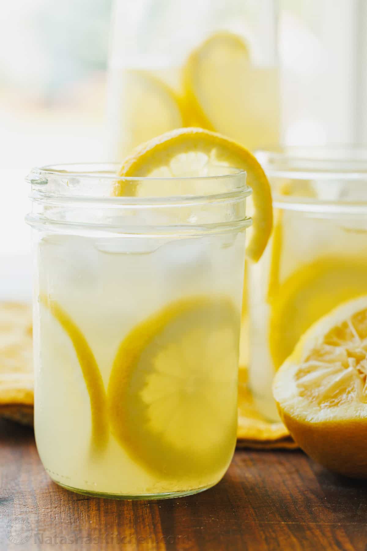 Our Lemonade recipe is so refreshing and easy with just 2 ingredients! Once you try homemade lemonade, it will spoil you forever. Glasses filled with homemade lemonade and ice