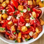 Panzanella Salad with tomatoes and crispy bread in a white serving bowl.