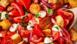 Panzanella Salad served in a white serving bowl garnished with basil