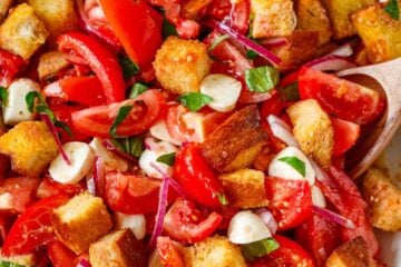 Panzanella Salad served in a white serving bowl garnished with basil