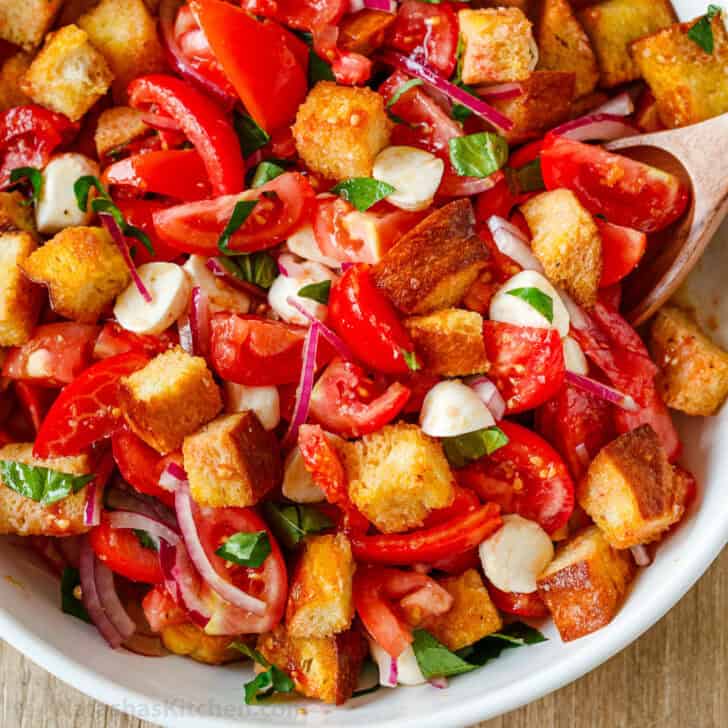 Panzanella Salad with tomatoes and crispy bread in a white serving bowl.