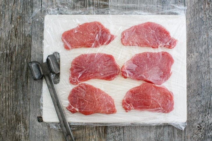 arranging pork cutlets on a cutting board