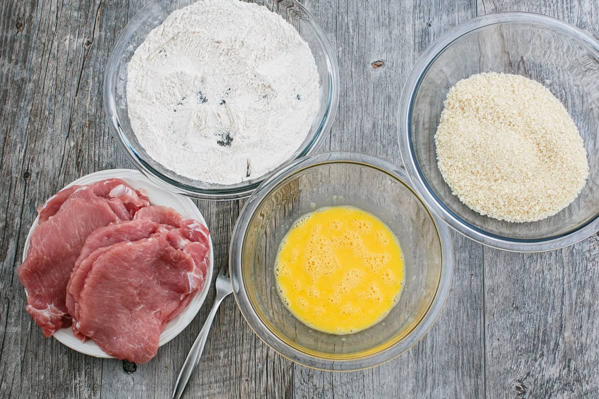 Breading stations set up for pork cutlets
