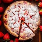 Fresh strawberry cake served with powdered sugar and strawberries