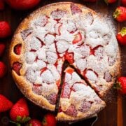 Fresh strawberry cake served with powdered sugar and strawberries