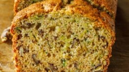 Zucchini Bread loaf sliced on a sheet of parchment paper