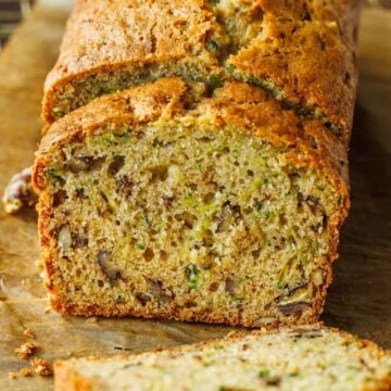Zucchini Bread loaf sliced on a sheet of parchment paper