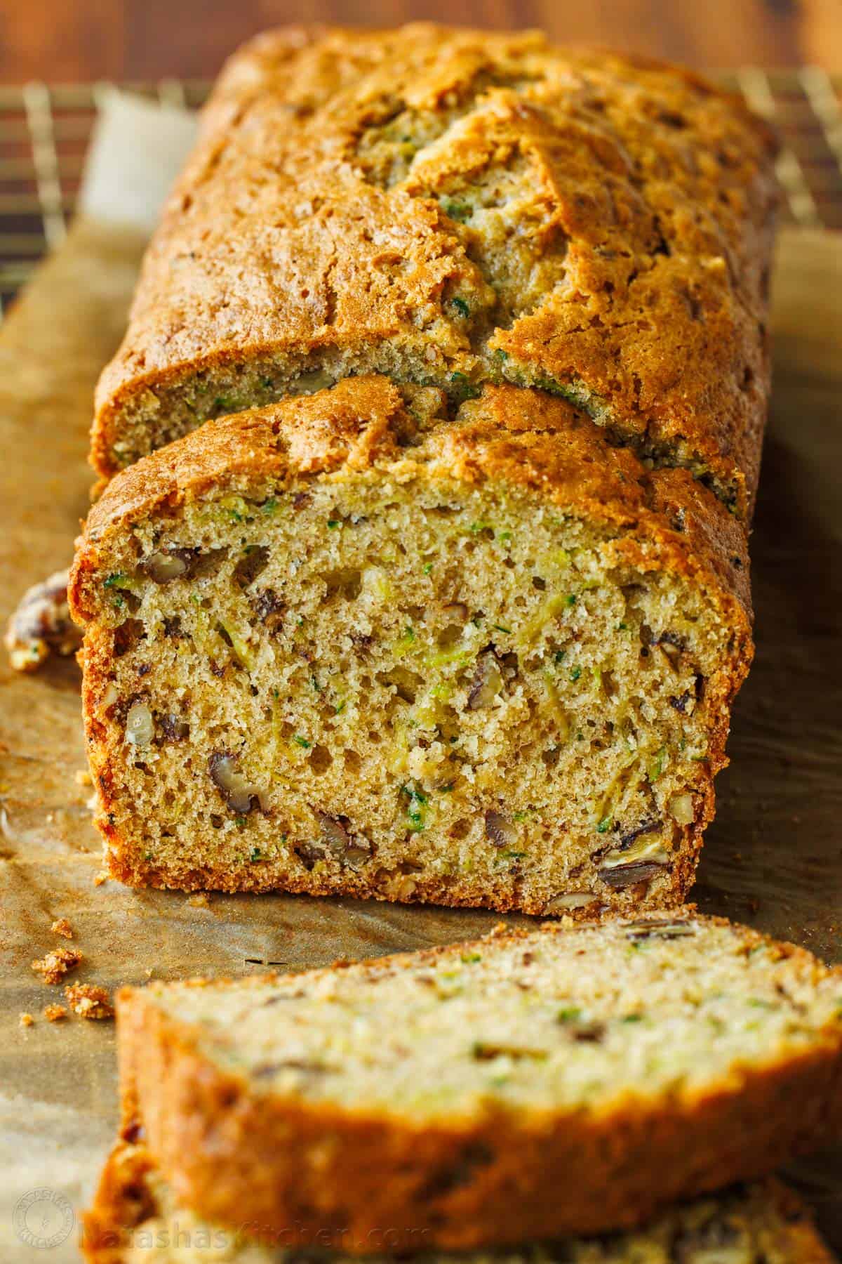 Zucchini Bread loaf sliced on a sheet of parchment paper