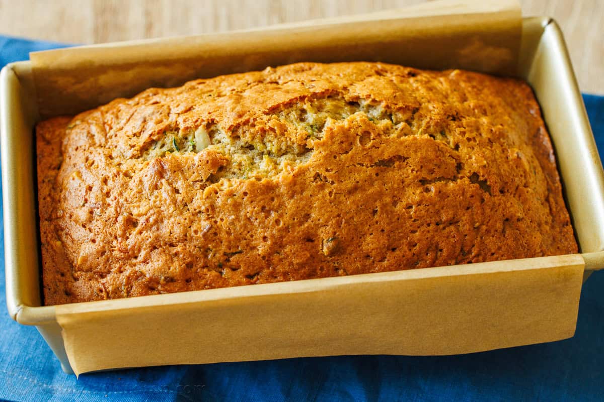 Baked zucchini bread in loaf pan with parchment paper