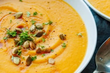 Roasted Butternut squash soup in a white serving bowl with spoon