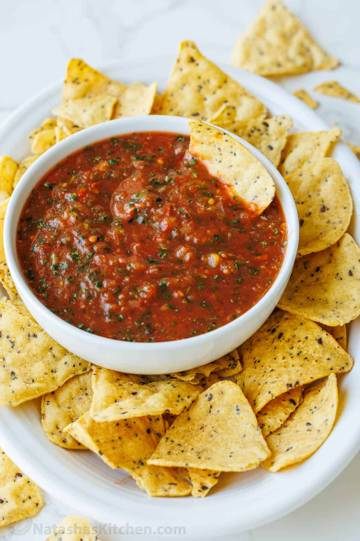 Easy Roasted tomato Salsa with smoky fire-roasted flavor, fresh cilantro, and a scoopable texture. Freezer-friendly and better than store-bought. bowl of roasted tomato salsa served with tortilla chips