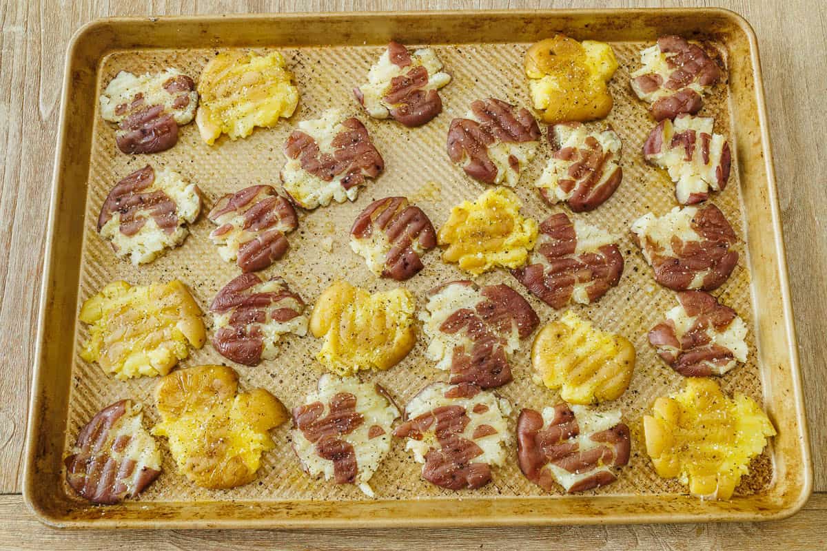 flattened spuds on a sheet pan with salt seasoning
