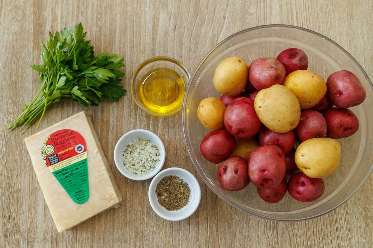 ingredients for starchy appetizer or side dish using spuds, parsley, Parmesan cheese, olive oil, garlic salt and black pepper