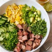 Steak Salad with honey lime dressing, corn, avocado, cucumber, green onion, cilantro and perfectly seasoned steak