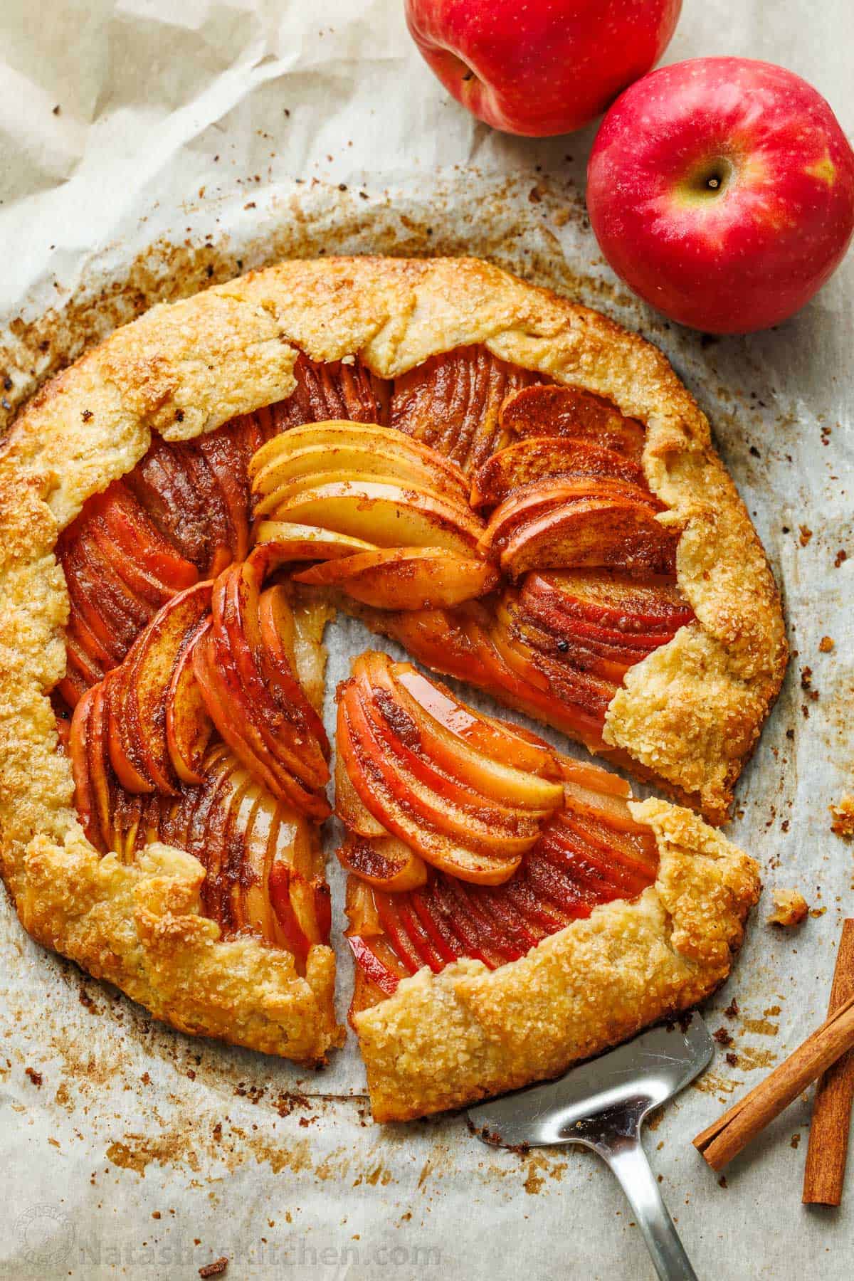 Easy Apple Galette with a flaky homemade crust and cinnamon apples. No pie plate or peeling needed for this beautiful rustic fall dessert. Slice of homemade apple galette lifted from the whole galette