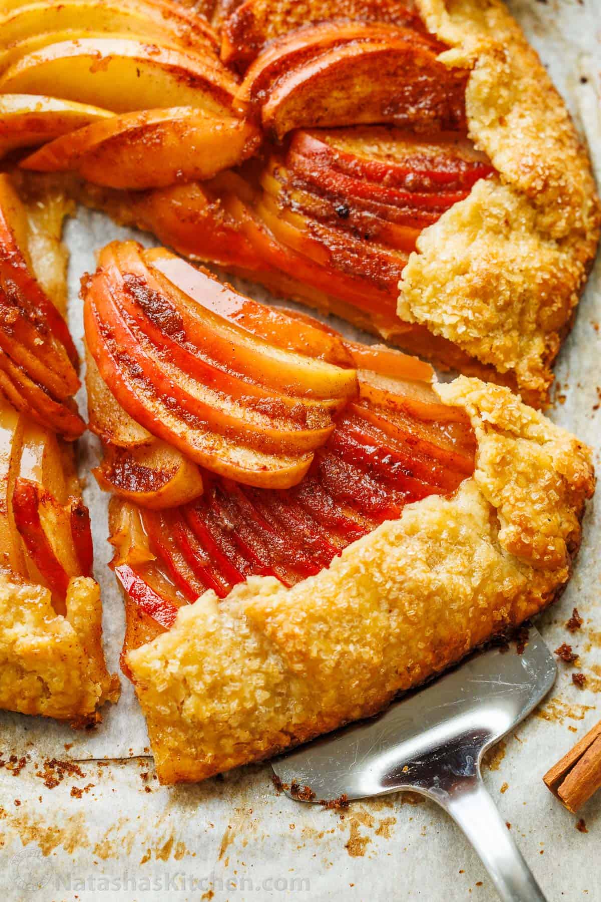 Easy Apple Galette with a flaky homemade crust and cinnamon apples. No pie plate or peeling needed for this beautiful rustic fall dessert. slice of fruit dessert on pie crust removed from whole pie