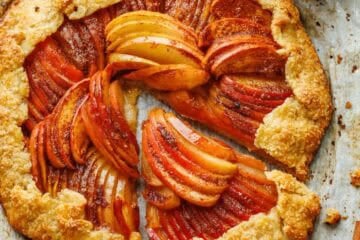 easy apple galette on parchment paper with sliced apples and brown sugar glaze