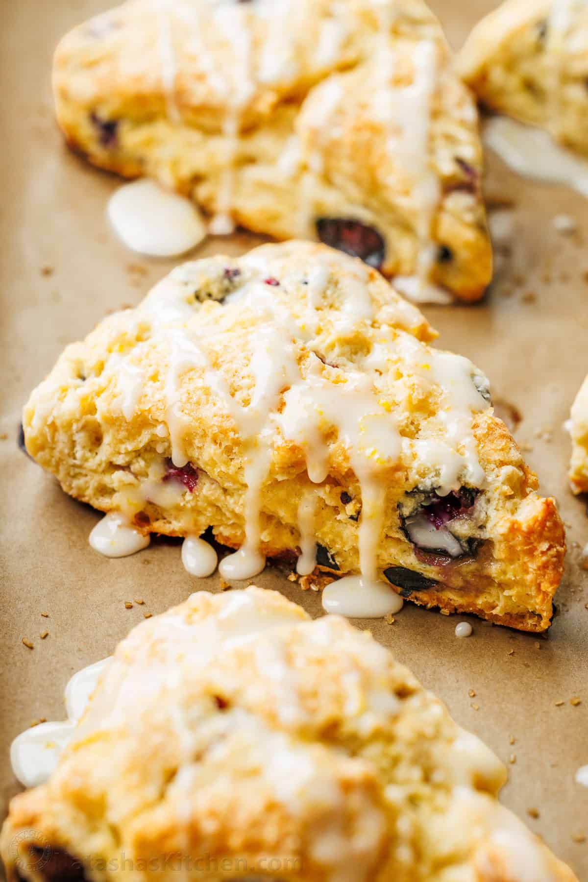 These easy Blueberry Scones are buttery, flaky, packed with juicy blueberries, and finished with a bright lemon glaze. Make-ahead friendly, too. Blueberry scones drizzled with lemon glaze