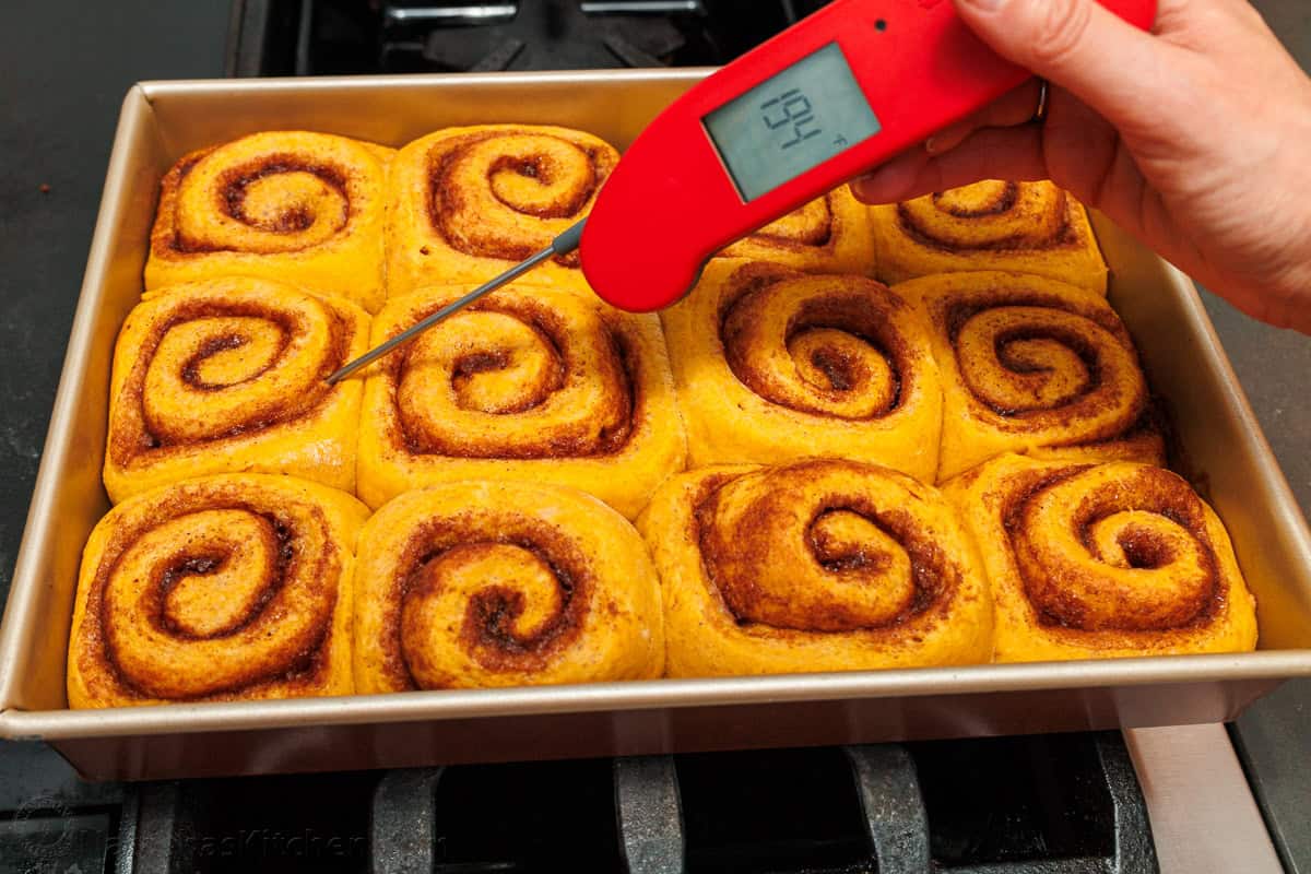 Using an instant-read thermometer to measure the temperature of a tray of baked pastries